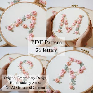 以下が含まれることがあります： 26文字のオリジナル刺繍デザインを収録したPDFパターン。各文字は白い布地に手刺繍されたピンクのバラと緑の葉で構成され、円形の木製刺繍枠に収められています。AI生成コンテンツは含まれていません。