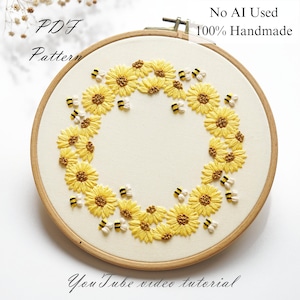 May include: Embroidered artwork in a wooden hoop, showcasing a wreath of yellow sunflowers and bees on cream fabric. Text reads "PDF Pattern", "No AI Used 100% Handmade", and "YouTube video tutorial". A handmade craft item.
