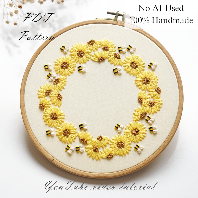 May include: Embroidered artwork in a wooden hoop, showcasing a wreath of yellow sunflowers and bees on cream fabric. Text reads "PDF Pattern", "No AI Used 100% Handmade", and "YouTube video tutorial". A handmade craft item.