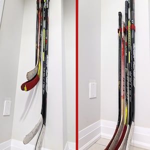 Puede incluir: Dos formas diferentes de guardar palos de hockey. A la izquierda, los palos est&aacute;n montados en la pared usando un m&eacute;todo de perforaci&oacute;n. A la derecha, los palos est&aacute;n montados en la pared usando cinta de doble cara. El texto "Off the Ground" y "On the Ground" es visible sobre cada conjunto de palos.