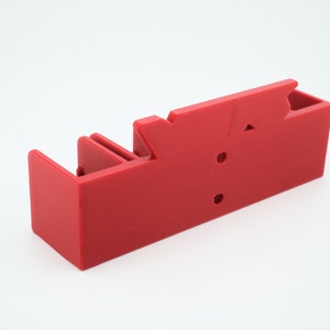 Puede incluir: Organizador de pl&aacute;stico rojo con m&uacute;ltiples compartimentos y una tapa con bisagras. El organizador tiene un dise&ntilde;o simple y es perfecto para guardar objetos peque&ntilde;os.