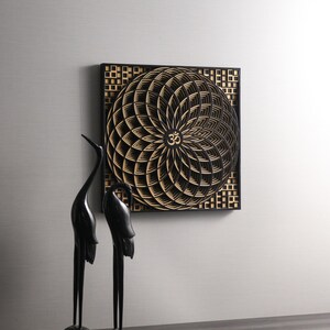 May include: Black and gold geometric wall art with a mandala design featuring the Om symbol in the center.