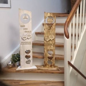 Könnte beinhalten: Zwei dekorative Holzschilder mit Herz-Ausschnitten und graviertem Text. Eines ist hell, das andere dunkler. Die Schilder werden auf einer Treppe ausgestellt. Der Text enthält die Zahlen "40" und "2023".