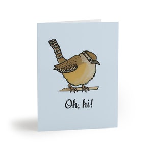 Könnte beinhalten: Eine Grußkarte mit einer Cartoon-Illustration eines braunen und braunen Vogels mit einem langen Schwanz, der auf einem Ast sitzt. Der Vogel schaut nach rechts und der Text "Oh, hi!" steht unter dem Vogel.