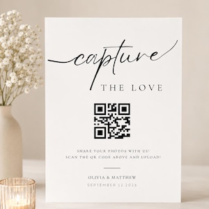May include: A white rectangular wedding sign with black text that reads capture THE LOVE, followed by a QR code, the instructions SHARE YOUR PHOTOS WITH US! SCAN THE QR CODE ABOVE AND UPLOAD!, and the names OLIVIA & MATTHEW with SEPTEMBER 12 2026.
