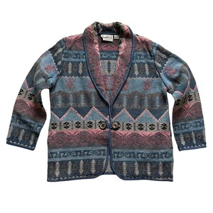 May include: A blue, pink, and brown patterned cardigan with a shawl collar and button closure. The cardigan has a woven design with geometric shapes and trees.