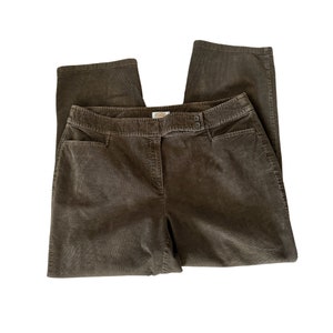 May include: Brown corduroy pants with a straight leg cut. The pants have a button and zipper closure, two front pockets, and a small logo tag on the waistband. The corduroy fabric has a ribbed texture.