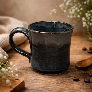 May include: A set of three ceramic mugs with a speckled, matte finish. The mugs are in shades of cream, light brown, and dark brown. Each mug has a simple, minimalist design, perfect for coffee or tea.