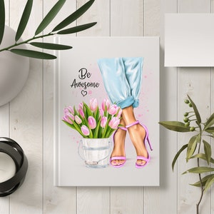 K&ouml;nnte beinhalten: Ein wei&szlig;es Notizbuch mit dem Text "Be Awesome" und einem rosa Herz. Das Notizbuch zeigt eine Aquarell-Illustration von Frauenbeinen, die blaue Jeans und rosa High Heels tragen. Die Frau h&auml;lt einen Eimer mit rosa Tulpen.