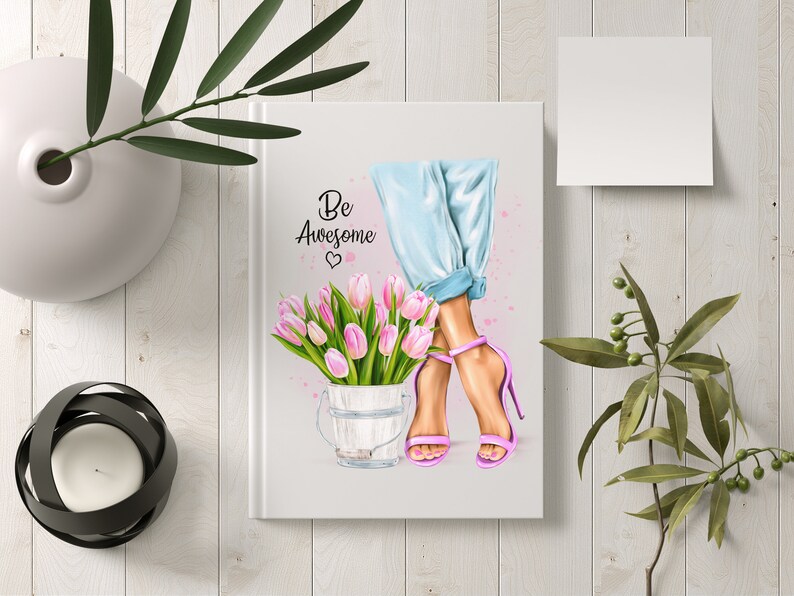 K&ouml;nnte beinhalten: Ein wei&szlig;es Notizbuch mit dem Text "Be Awesome" und einem rosa Herz. Das Notizbuch zeigt eine Aquarell-Illustration von Frauenbeinen, die blaue Jeans und rosa High Heels tragen. Die Frau h&auml;lt einen Eimer mit rosa Tulpen.