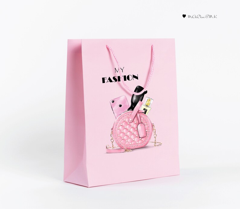May include: Pink shopping bag with the text "MY FASHION" printed on the front. The bag features a pink quilted handbag with a gold chain strap, sunglasses, a phone, and a bottle of perfume inside.