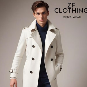 Puede incluir: Un abrigo blanco de gabardina de doble botonadura con cintur&oacute;n y botones marrones. El abrigo tiene un cuello alto y est&aacute; hecho de una tela lisa.  ZF CLOTHING MEN'S WEAR est&aacute; escrito en negro en la parte superior de la imagen.