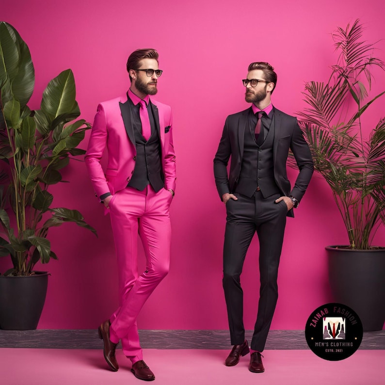 May include: Two men wearing suits, one in a bright pink suit and the other in a black suit, stand in front of a pink wall. Both men are wearing glasses and have their hands in their pockets. The pink suit has a black vest and a black tie. The black suit has a black vest and a black tie. The background includes two potted plants.