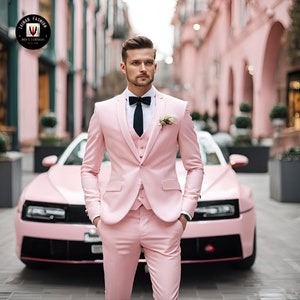 Puede incluir: Un hombre con un traje rosa, corbata de lazo negra y un boutonniere de flor blanca. Est&aacute; de pie frente a un coche rosa.