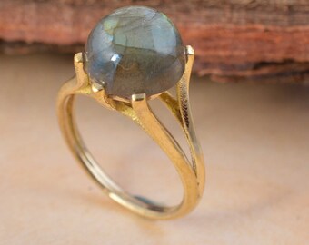Può includere: Un anello d'oro con una grande pietra preziosa rotonda e iridescente in labradorite.