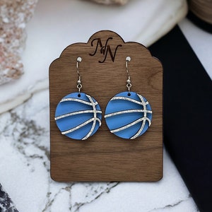 Game day Carolina blue and white glitter layered wood basketball earrings. Super lightweight wood basketball earrings. Hand cut/painted.