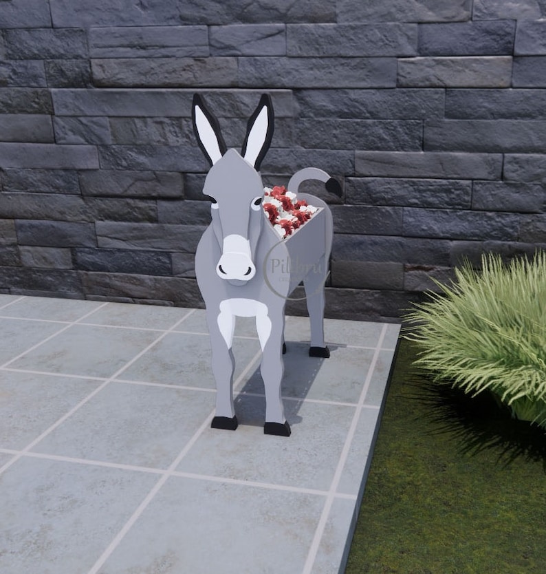 May include: A gray donkey-shaped planter with black ears and hooves. The planter's body is hollow, filled with red and white flowers. The donkey stands on a tiled surface in front of a dark gray stone wall. The planter is a unique garden decoration.