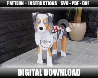 Puede incluir: Un patrón de descarga digital para una maceta de madera con forma de perro pastor australiano. El perro está de pie sobre cuatro patas y tiene una maceta en la espalda. El perro está pintado en tonos de azul, blanco y marrón. La maceta está pintada en tonos de gris y negro. El patrón incluye instrucciones para construir la maceta.