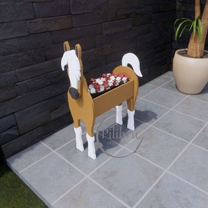 May include: A wooden horse planter with white accents. The planter is filled with red and white flowers. The horse is standing on a tiled floor.