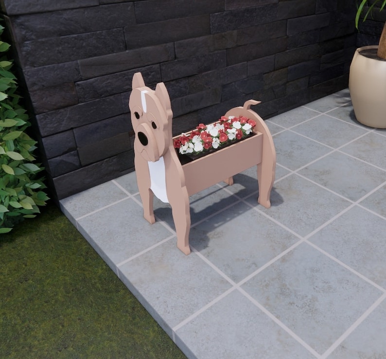 May include: A light brown planter shaped like a dog with white markings. The planter is filled with pink and white flowers. The planter is sitting on a gray tiled floor.