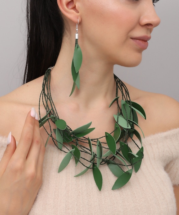 Handmade necklace and earring set with leaf motif, made from green leather.