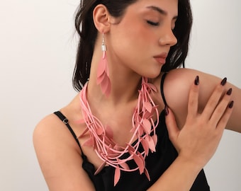 Artisan necklace and earring set made of pink leather with a leaf pattern.