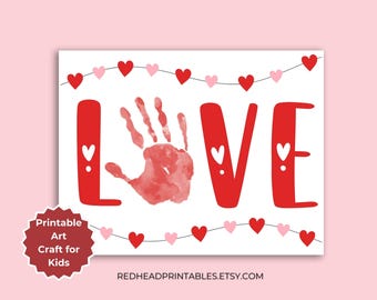 May include: Printable Valentine's Day craft for kids featuring the word "LOVE" with a handprint in the "O". The letters are red and there is a string of pink and red hearts above and below the word.