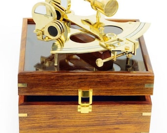 May include: A brass sextant with a telescope and two mirrors, in a wooden box with a glass top. The box has a brass latch.