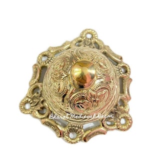 May include: A gold-toned metal bell with an ornate design. The bell has a round top and a decorative base. The bell is a traditional design.