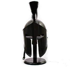Puede incluir: Un casco espartano negro con una pluma de crin de caballo negra sobre un soporte negro.
