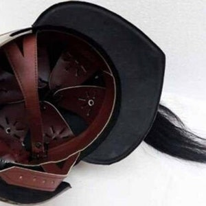 K&ouml;nnte beinhalten: Ein mittelalterlicher Helm mit schwarzem Lederfutter und einer schwarzen Rosshaar-Feder. Der Helm ist aus Metall und hat ein braunes Lederinnere.