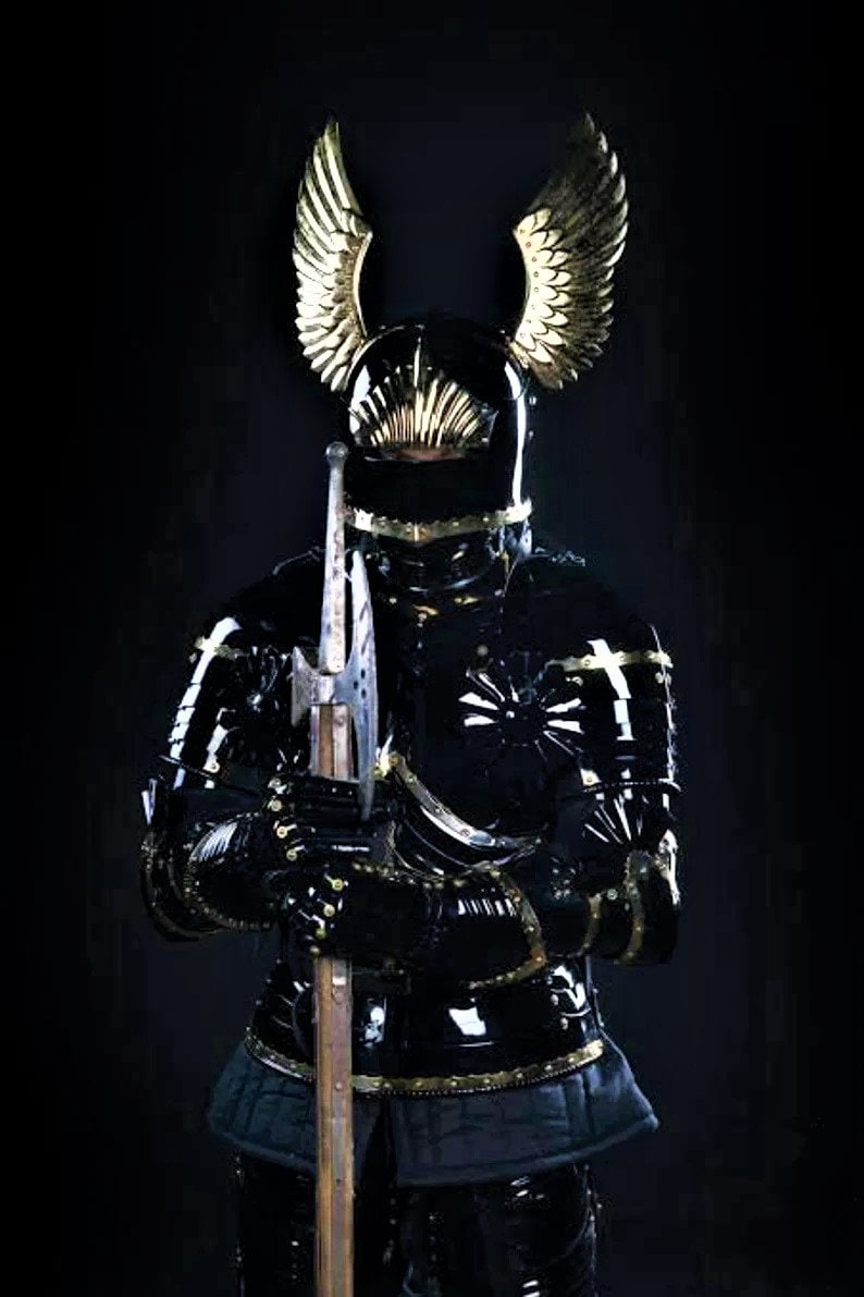 May include: A black and gold knight's armor with a helmet featuring winged accents. The armor is detailed with gold trim and the knight is holding a spear.