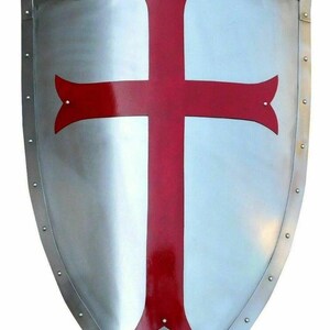 Puede incluir: Un escudo plateado con una cruz roja en el centro. El escudo tiene una parte superior redondeada y una parte inferior puntiaguda. Est&aacute; decorado con peque&ntilde;os remaches met&aacute;licos alrededor del borde.