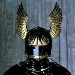 May include: A black knight's helmet with gold wings and a black visor. The helmet is part of a full suit of armor.