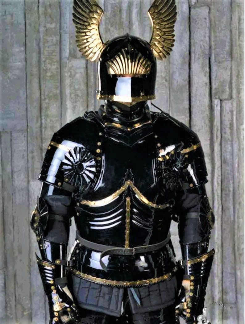 May include: A black and gold knight's armor with a helmet featuring golden wings. The armor is detailed with gold accents and rivets.