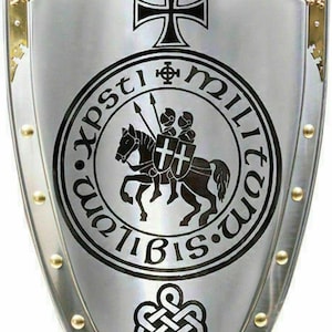 Puede incluir: Un escudo plateado con una cruz negra, una imagen en blanco y negro de un caballero a caballo, y el texto "XPSTI MILITVM IBIS.VM" en un c&iacute;rculo. El escudo tiene un borde dorado y un nudo dorado en la parte inferior.