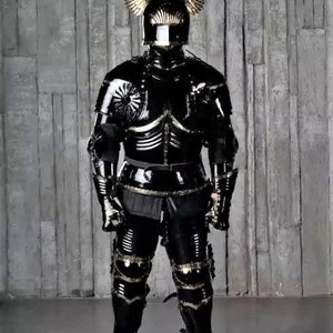 May include: A full suit of black armor with gold accents. The armor includes a helmet with a visor and winged helmet crest. The armor is standing on a gray background.