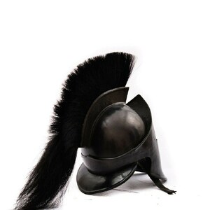 Puede incluir: Un casco de guerrero griego negro con una larga pluma de crin de caballo negra. El casco est&aacute; hecho de metal y tiene una forma distintiva con una cresta puntiaguda.