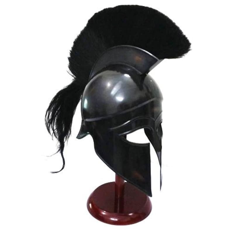 K&ouml;nnte beinhalten: Ein schwarzer spartanischer Helm mit einer schwarzen Rosshaar-Feder, auf einem Holzst&auml;nder. Der Helm hat eine charakteristische Gesichtsmaske mit einem vertikalen Schlitz f&uuml;r die Augen.