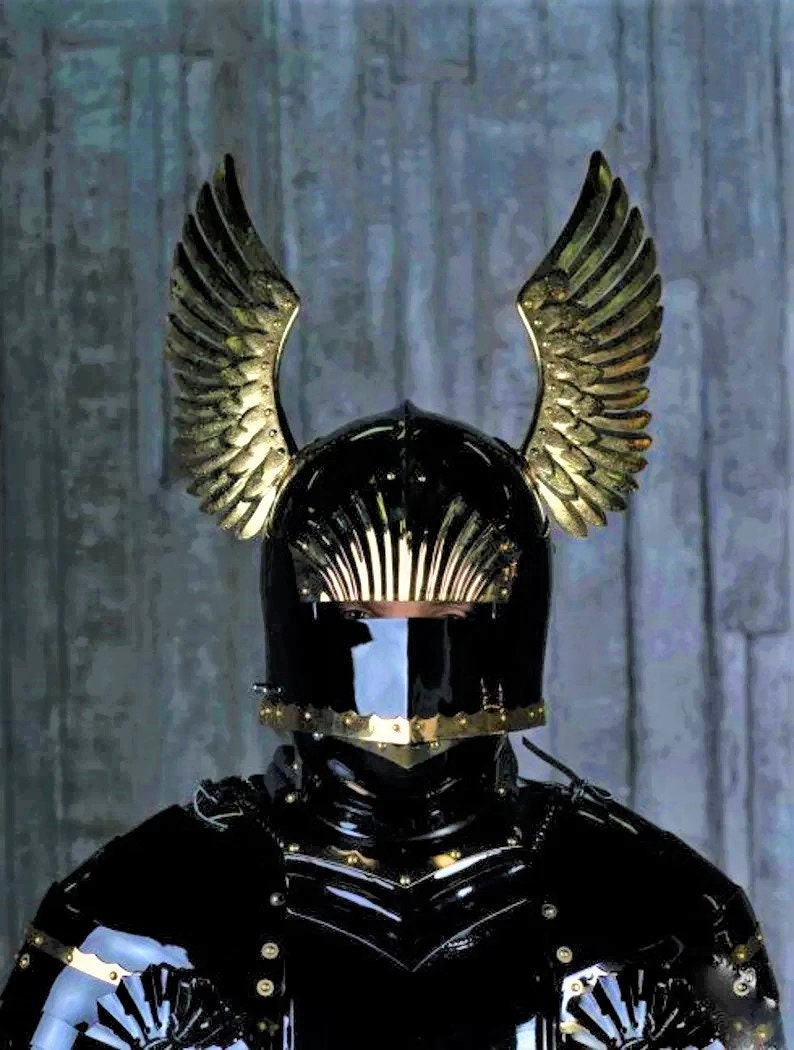 May include: A black knight's helmet with gold accents and a pair of golden wings attached to the top.