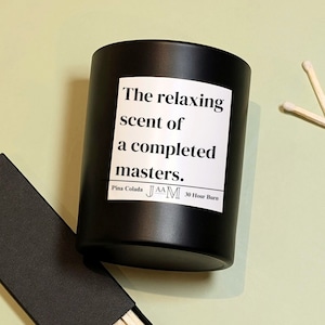 Peut inclure: Bougie noire avec une étiquette blanche qui indique "The relaxing scent of a completed masters. Pina Colada JAA M 30 Hour Burn"