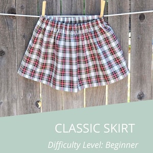 May include: A plaid skirt with a white, red, and black pattern. The skirt is hanging on a clothesline with wooden clothespins. The text "CLASSIC SKIRT" and "Difficulty Level: Beginner" is below the skirt.