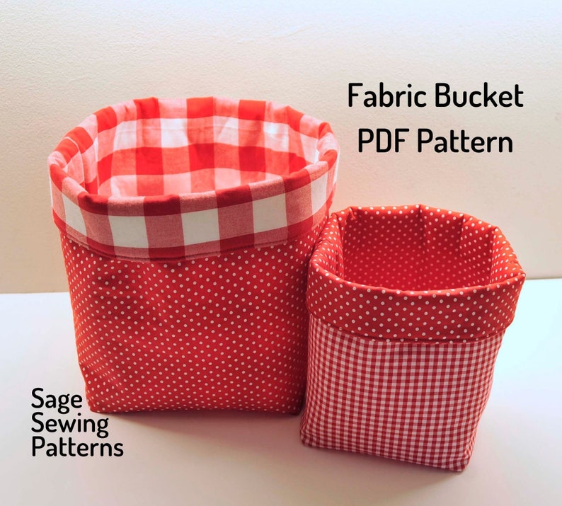 Puede incluir: Dos cubos de tela rojos con lunares blancos y patrones de cuadros. El cubo m&aacute;s grande tiene un forro de cuadros y el cubo m&aacute;s peque&ntilde;o tiene un forro de lunares. El texto "Fabric Bucket PDF Pattern" y "Sage Sewing Patterns" es visible en la imagen.