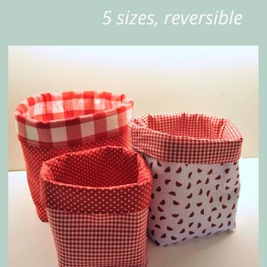 Puede incluir: Tres cestas de tela en forma de cubo de diferentes tama&ntilde;os. Las cestas son reversibles y presentan un estampado de cuadros rojos y blancos, rojo con lunares blancos y blanco con rodajas de sand&iacute;a rojas. El texto "FABRIC BUCKET BASKET 5 sizes, reversible" est&aacute; en la parte superior de la imagen. El texto "SAGE SEWING PATTERNS" est&aacute; en la parte inferior de la imagen.