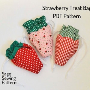 Könnte beinhalten: Drei stoffene Leckerei-Beutel in Form von Erdbeeren mit grünen Oberteilen und verschiedenen Mustern. Die Beutel sind mit weißem Band gebunden. Der Text "Strawberry Treat Bag PDF Pattern" befindet sich oben im Bild. Der Text "Sage Sewing Patterns" befindet sich unten im Bild.