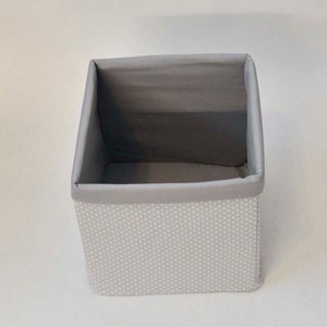 May include: A gray fabric storage box with white polka dots. The box is empty and has a gray fabric lining.