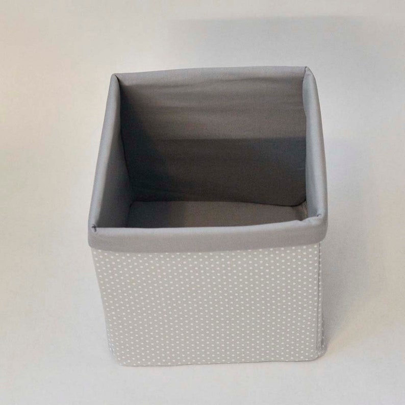 May include: A gray fabric storage box with white polka dots. The box is empty and has a gray fabric lining.