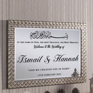 May include: A silver framed mirror with a wedding announcement. The announcement includes the Arabic phrase "Bismillah ir-Rahman ir-Rahim", which translates to "In the name of God, the Most Gracious, the Most Merciful". The announcement also includes the names "Ismail & Hannah" and the date "14th February 2024".
