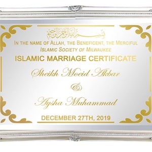 May include: A silver framed mirror with a gold Islamic marriage certificate. The certificate reads "In the name of Allah, the beneficent, the merciful. Islamic Society of Milwaukee. Islamic Marriage Certificate. Sheikh Moeid Akbar & Aysha Muhammad. December 27th, 2019."