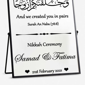 Puede incluir: Un cartel negro enmarcado con fondo blanco y texto negro. El cartel dice "And we created you in pairs" y "Surah An Naba (78:8)". Debajo del texto hay una línea y las palabras "Nikkah Ceremony". Los nombres "Samad & Fatima" están escritos en cursiva debajo de la línea. La fecha "21st February 2021" está escrita debajo de los nombres. Dos corazones negros están a cada lado de la fecha.